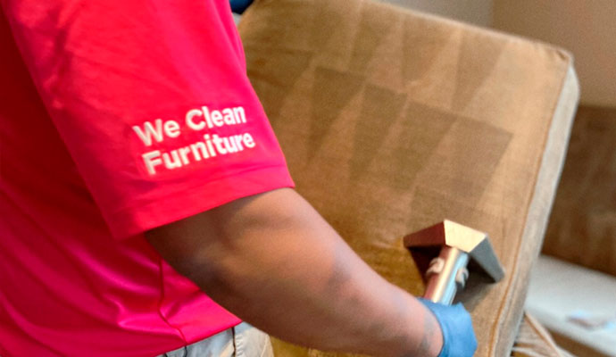 Professional worker cleaning upholstered chair