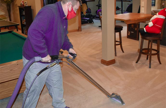 Worker using a vacuum cleaner for cleaning service.