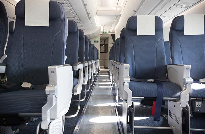 Empty and clean airplane cabin with blue chairs.