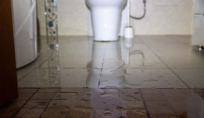 Overflowing water damage in bathroom floor