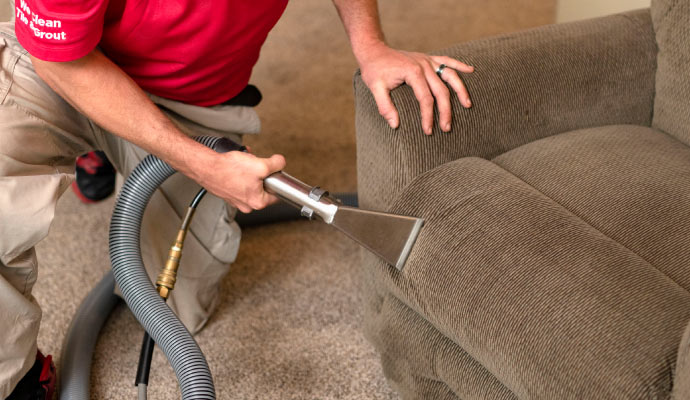 Person cleaning upholstery with equipment