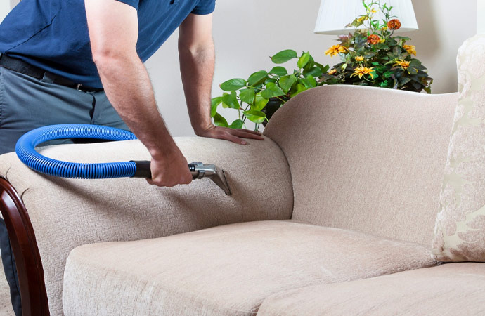 A person is upholstery cleaning with vacuum cleaner